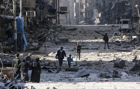 Los ciudadanos caminan entre los escombros en una de las barriadas periféricas de Alepo. :: Abdalrhman Ismail / Reuters