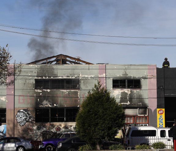 El edificio, tras el incendio. A la derecha, llamas en el local.