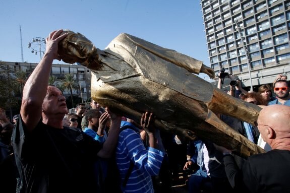 La estatua dorada de Netanyahu y su autor Itay Zalait, que trató de plantarla en Tel Aviv.
