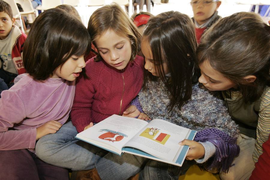 Un grupo de niñas lee un cuento ilustrado.