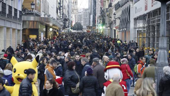 Decenas de ciudadanos caminan estas navidades por una de las calles más comerciales de Madrid. 