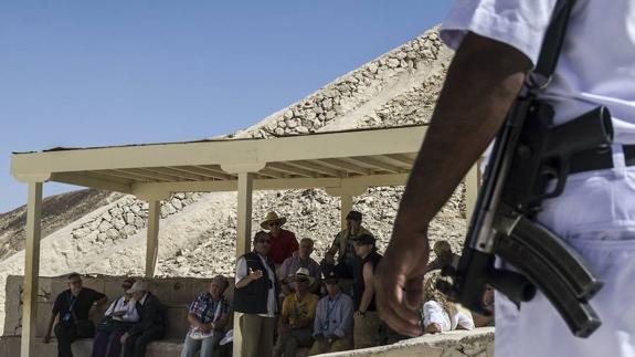 Un policía turístico patrulla junto a un grupo de visitantes en el Valle de los Reyes.