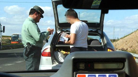 Un agente de la Guardia Civil multa a un conductor por exceso de velocidad.