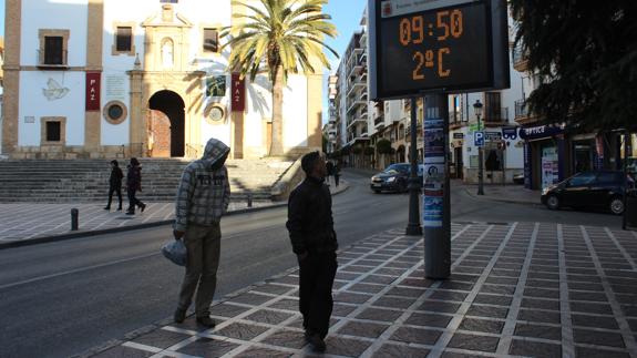 Dos vecinos de Ronda miran un termómetro.