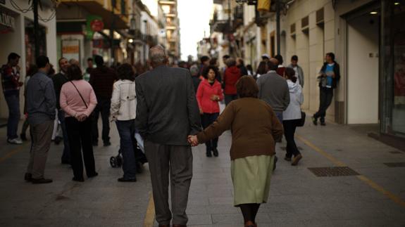 Pareja de pensionistas pasea por una calle peatonal de Ronda.
