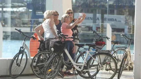 Turistas inmortalizan su visita a Málaga, en un parada de su recorrido en bicicleta.