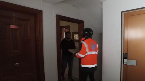 Momento de la llegada del repartidor de pizza. 