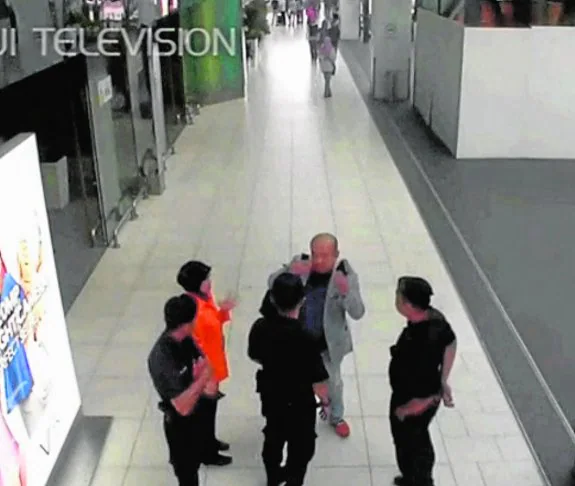 Las cámaras de seguridad muestran a Kim hablando a la policía del aeropuerto. :: reuters