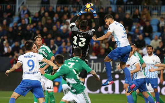 Jugadores de ambos equipos luchan por el balón. 