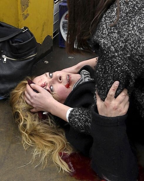 Una mujer yace debajo de un autobús (imagen superior) tras el ataque del terrorista en Londres; en la imagen inferior, una herida recibe los primeros auxilios de una ciudadana antes de que lleguen los servicios de emergencia. :: Toby Melville / reuters