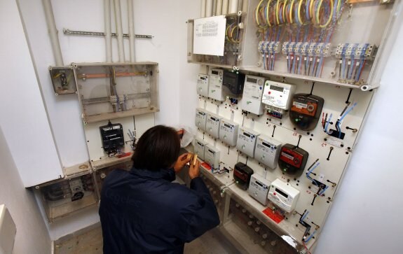 Un operario revisa los contadores de la luz en un edificio de viviendas. :: Avelino Gomez