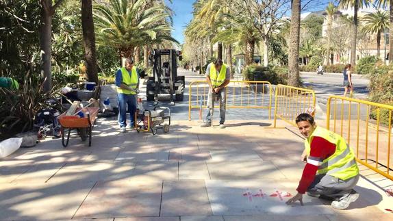 Operarios cambiando losetas de mármol en el Parque.