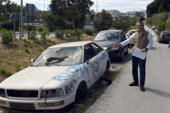 El concejal del PP José Eduardo Díaz refiere los problemas de Banús junto a un coche abandonado. 