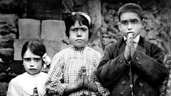 Los hermanos Jacinta y Francisco Marto posan junto a su prima Lucia Dos Santos (centro) en 1917. 