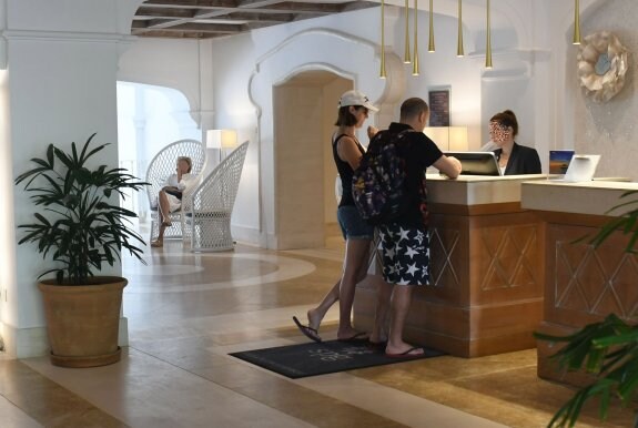Turistas se registran en la recepción de un hotel. :: sur
