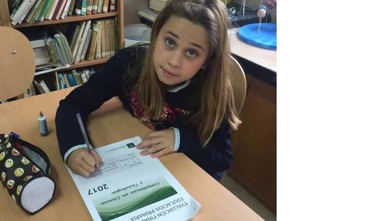 Una niña, con el cuadernillo de ejercicios de 6º. de Primaria.