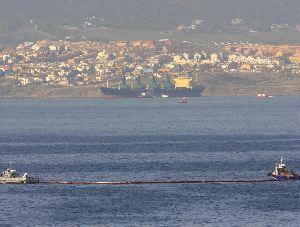 SEGURIDAD. Barrera anticontaminación en la Bahía y, al fondo, el                                     'Tawe'. / ANDRÉS CARRASCO