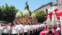 Unos turistas contemplan la procesión en una terraza de la plaza de Los Naranjos. / JOSELE-LANZA