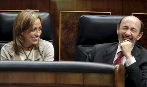 Los ministros Carme Chacón y Alfredo Pérez Rubalcaba bromean durante el pleno del Congreso de ayer. / EFE