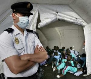 Un agente de la Policía Nacional custodia a un grupo de subsaharianos llegado en patera a Canarias. ::
EFE