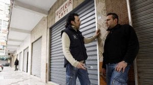 Dos vecinos de San Andrés en paro conversan en una calle del barrio en la que la mayoría de los comercios se han visto obligados a echar el cierre por la crisis ::                             SALVADOR SALAS