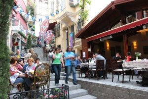 Turistas toman un café en una terraza de una calle típica de Turquía,         mientras una pareja recorre la ciudad. ::
SUR