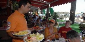 Un camarero atiende la mesa de uno de los muchos restaurantes que se agolpan en el paseo marítimo. ::
JOSELE-LANZA