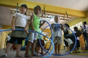 Niños jugando con aros en la escuela de verano del colegio Manuel Altolaguirre. ::                             ÁLVARO CABRERA