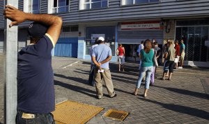 Varias personas esperan en una cola a la entrada de una oficina de empleo. ::
REUTERS