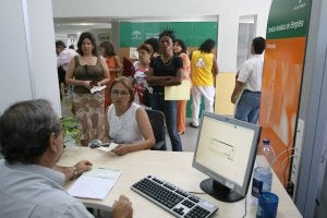 Un funcionario atiende a demandantes de empleo en las instalaciones del Servicio Andaluz de Empleo en la barriada de Gamarra. ::
C. MORET