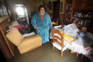 Una vecina del barrio del Rinconcillo de Algeciras, en el salón de su casa anegado de agua. ::
A. CARRASCO. EFE