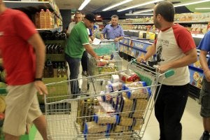 Miembros del Sindicato Andaluz de Trabajadores cargan carros de alimentos en un supermercado de Écija. :: Efe