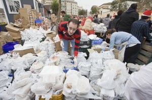 Uno de los voluntarios de la ONG organiza los platos de comida. :: Pepo Alcalá