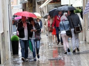 Transeúntes, ayer en el Centro bajo la lluvia. :: Carlos Moret