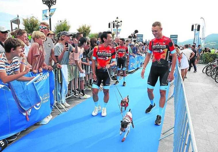 Arashiro y Milan bromean con dos perros en el paseíllo de los ciclistas por Alderdi Eder.