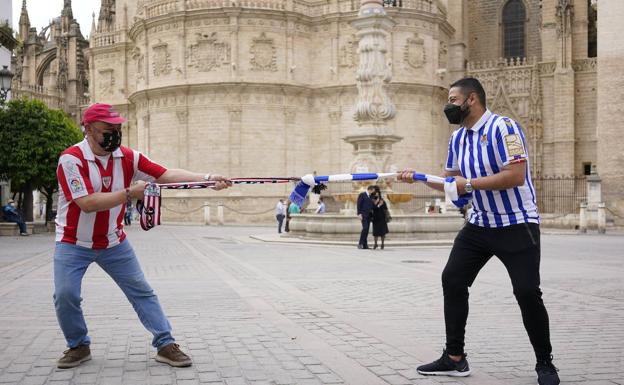 De la Fuente y Carrasco improvisan una competición de soka-tira con las bufandas de sus equipos, junto a La Giralda..