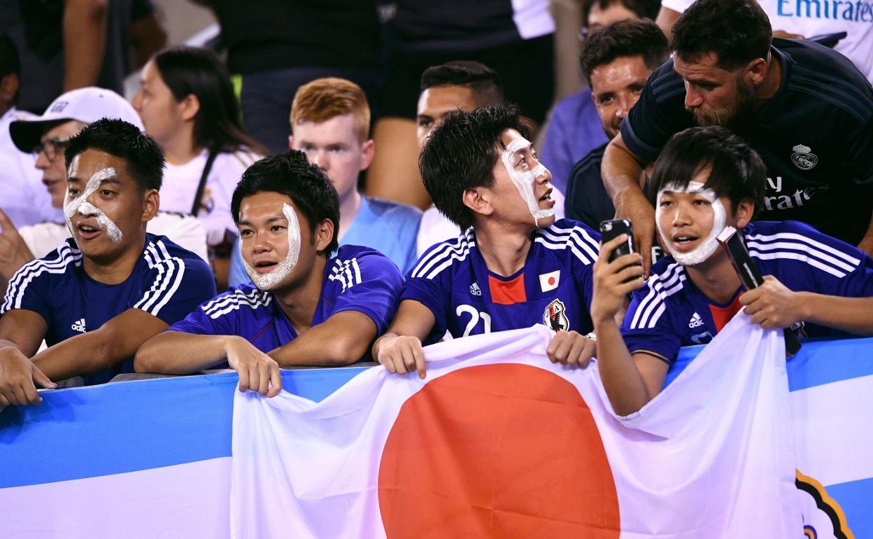Aficionados japoneses pintados con el nombre de Kubo durante un partido del Real Madrid. 