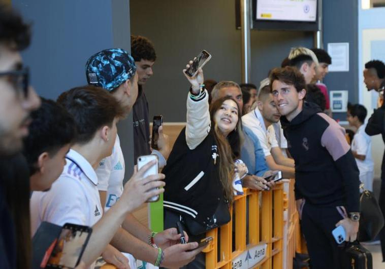 Una aficionada se hace una fotografía junto a Álvaro Odriozola a su llegada al aeropuerto de Hondarribia.