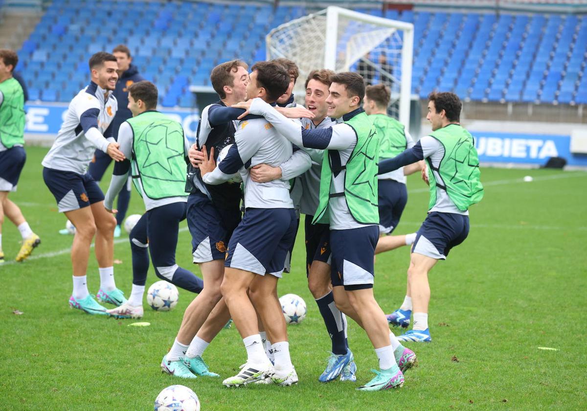 Los jugadores de la Real Sociedad se abrazan en un juego del entrenamiento de este martes en Zubieta, con André Silva detrás.