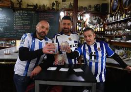 Hinchas de la Real Sociedad esperan en una cafetería del aeropuerto de Loiu a que les anuncien su vuelo a Palma de Mallorca.