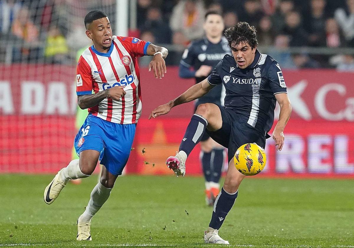 Jon Mikel Aramburu protege el balón ante la presión de Savio durante el encuentro entre el Girona y la Real Sociedad.