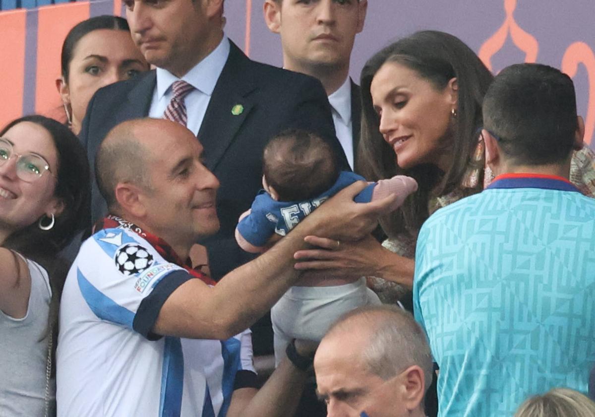 Letizia sostiene en brazos a la pequeña Leire ante la atenta mirada de su padre.