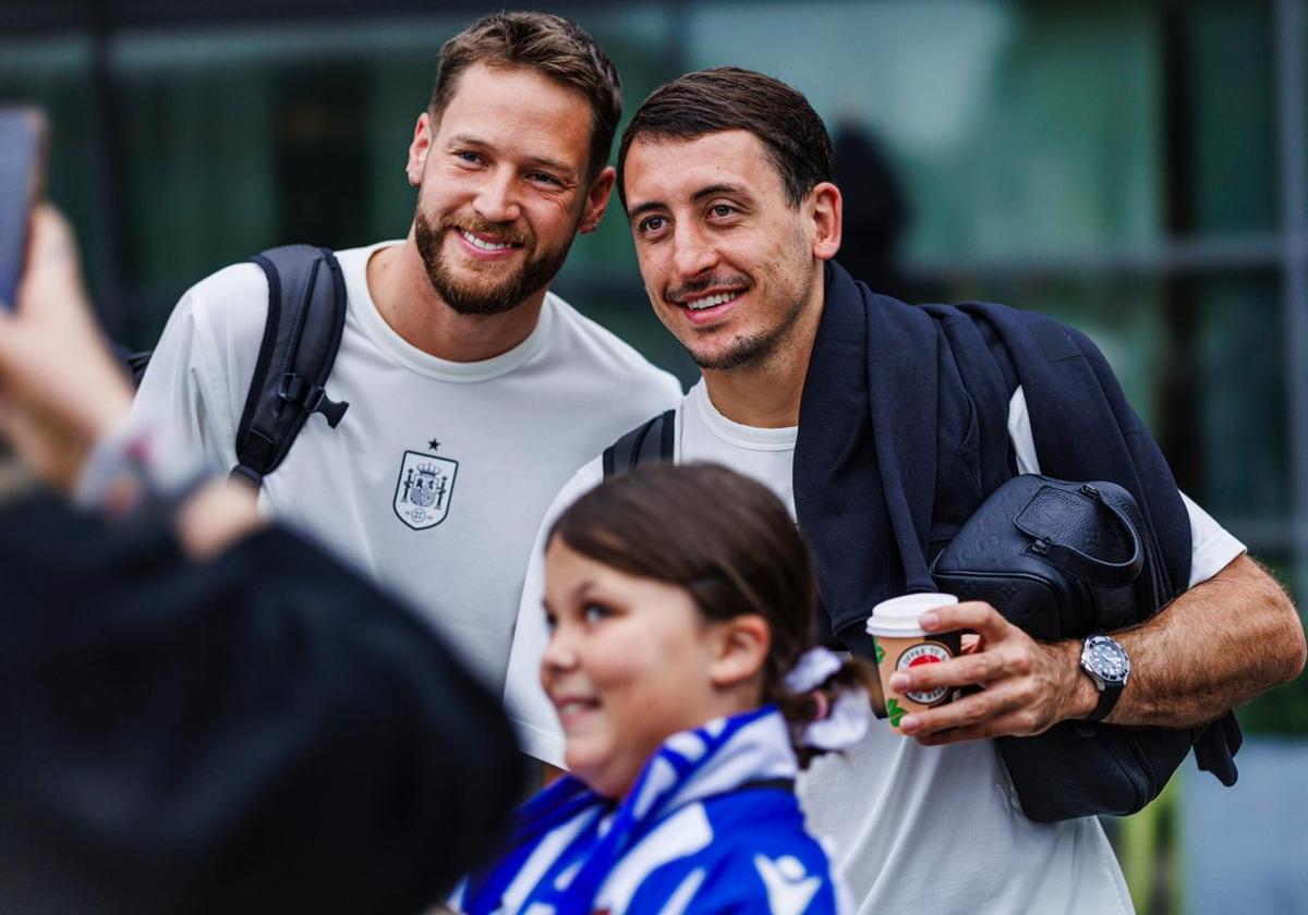 Álex Remiro y Mikel Oyarzabal posan junto a la joven aficionada de la Real Sociedad alemana.