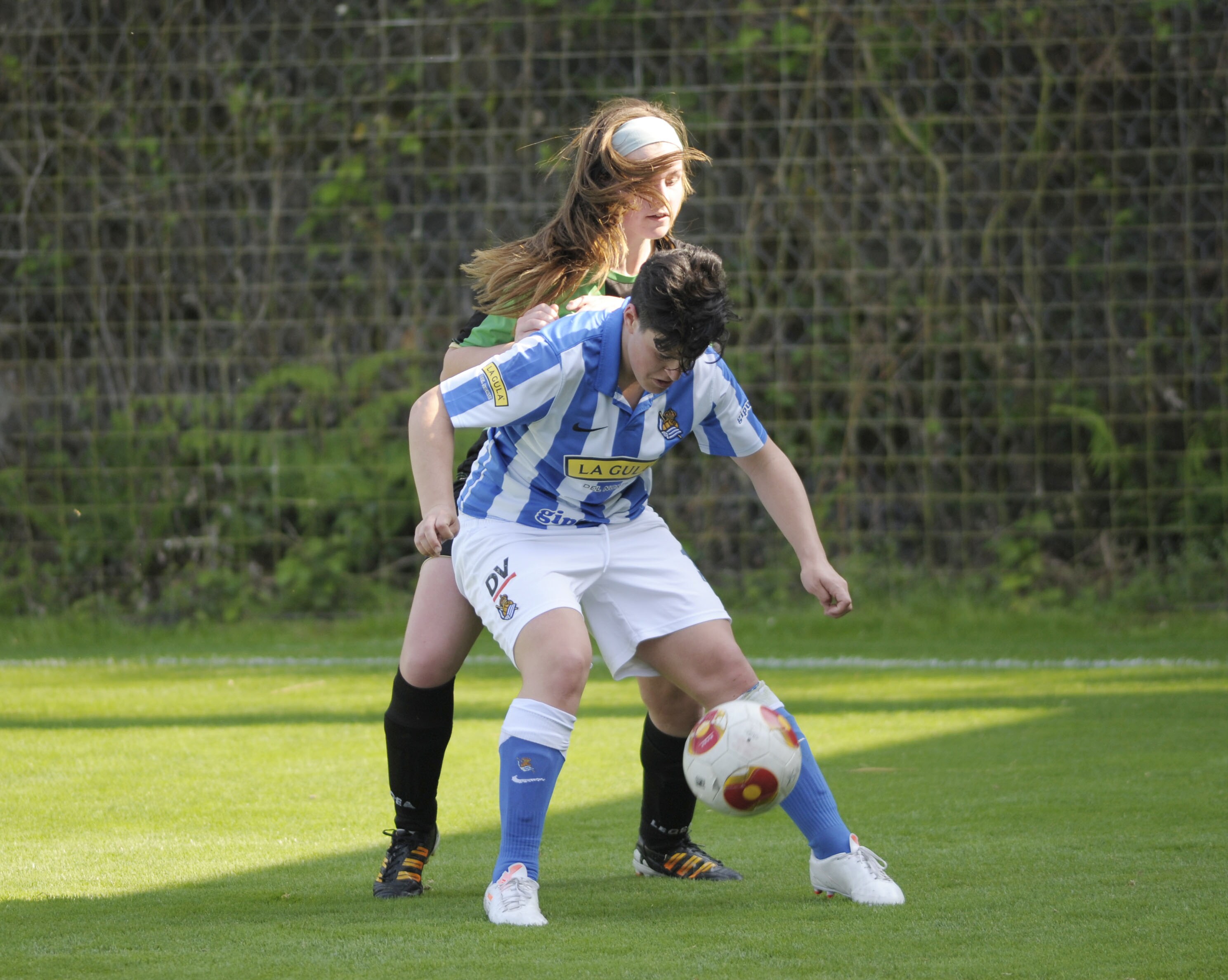 Marina Agoues defiende un balón ante el acoso de una defensora del Oviedo Moderno. 