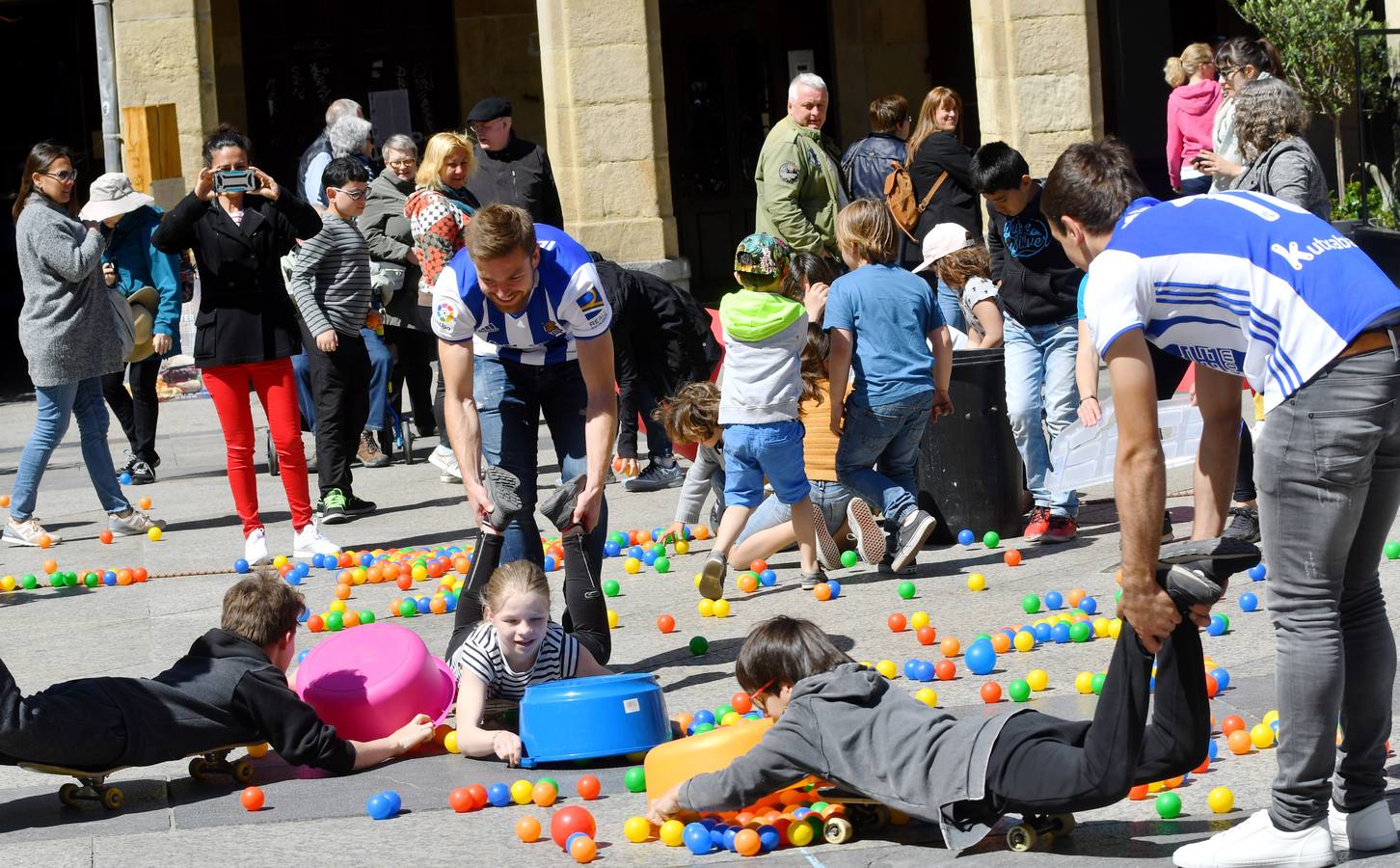 Illarra y Oyarzabal juegan con un grupo de niños en la plaza de la Constitución de Donostia.