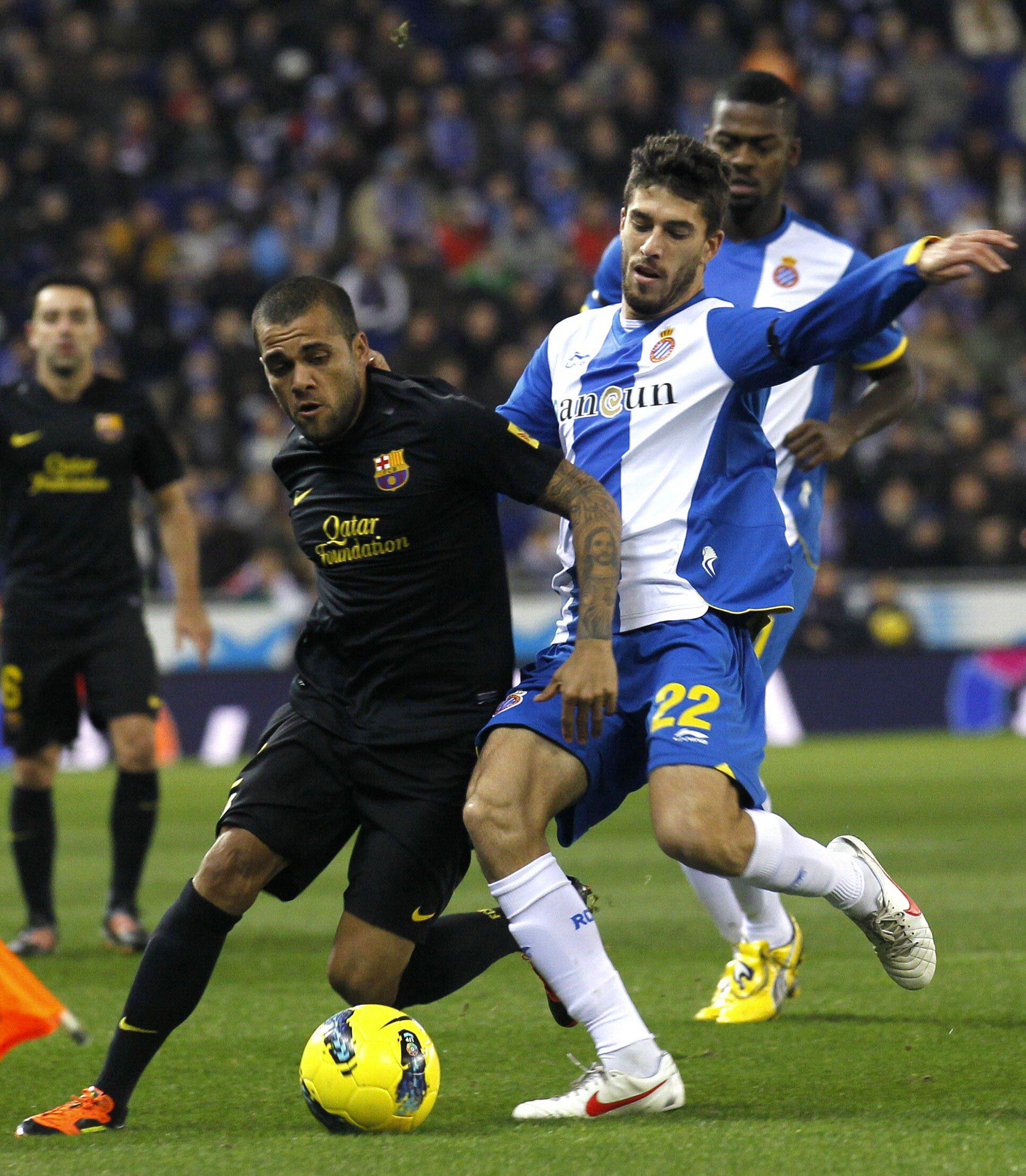 Dani Alves y Dídac Vilá disputan un balón durante un encuentro entre el F.C. Barcelona y e R.C.D. Espanyol.
