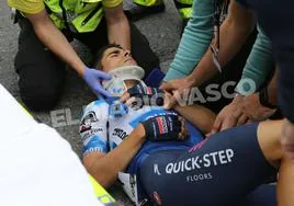 Mikel Landa tendido en el asfalto mientras los sanitarios le colocan un collarín.