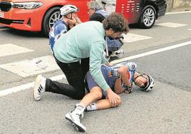 Mikel Landa tendido en el asfalto mientras los sanitarios le colocan un collarín.