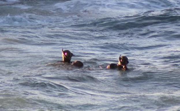 La Guardia Civil saca del agua el cuerpo del inmigrante subsahariano. 