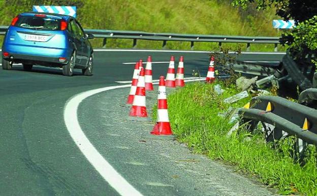 Un coche transita por una carretera en pleno proceso de reparación por daños.